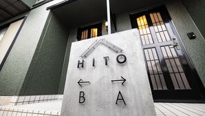A sign with directional arrows and the letters "HITO" and "BA" indicating a hotel entrance. - HITO (Fukuoka)