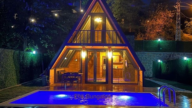 A bungalow with a swimming pool, surrounded by a well-lit garden at night. - EHLI BUNGALOV (Sapanca)