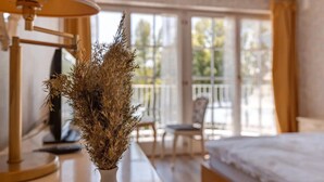 A hotel room with a bed, a chair, a table, and a window with a view of the outdoors. - Room 'Mit Seeblick Und Balkon' with Lake View, Shared Terrace and Wi-Fi (Reichenau)
