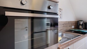 Una cocina moderna con electrodomésticos de acero inoxidable, microondas integrado y encimera de madera.