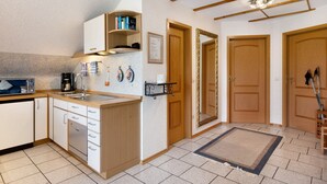 A kitchen with wooden cabinets, a built-in microwave, and a coffee maker.
