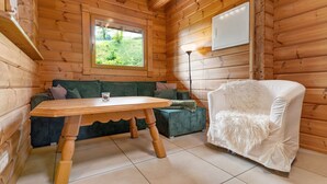 Un interior de madera con una mesa de madera, un sofá y una silla blanca.