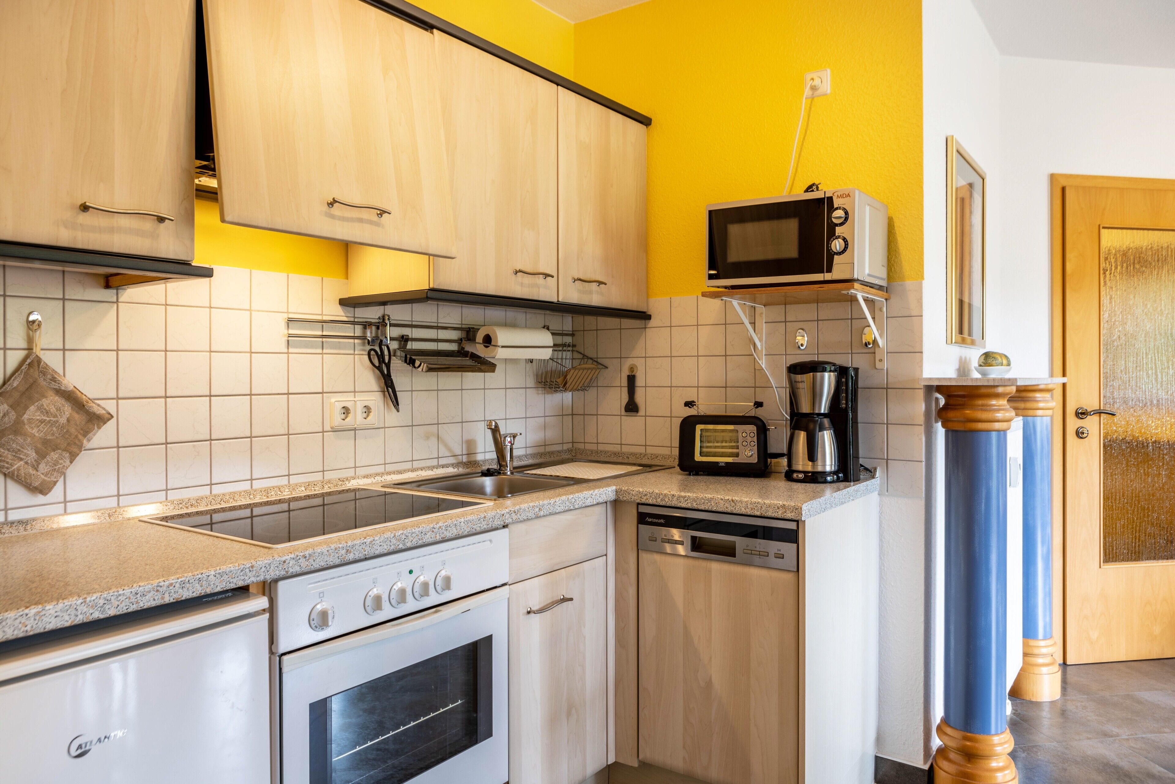 A kitchen with wooden cabinets, a microwave, a dishwasher, and a coffee maker.