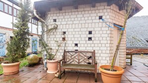 A brick building with a bench and potted plants. - Farmhouse 'Zur Henne' with Shared Terrace and Wi-Fi (Weinbach)