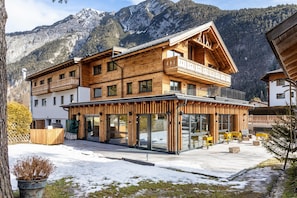 A wooden chalet with balconies, large windows, and a mountain backdrop. - Apartment 'Alte Mühle' with Mountain View and Wi-Fi (Scharnitz)