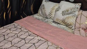 Ein Schlafzimmer mit Bett, Deckenventilator und einem fenster mit Vorhängen.