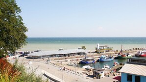 Een kustplaats met een jachthaven, gebouwen en een strand.