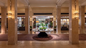 A spacious lobby with a central round table, columns, and potted plants. - The ERAVATI Sule Grand Yangon (Yangon)