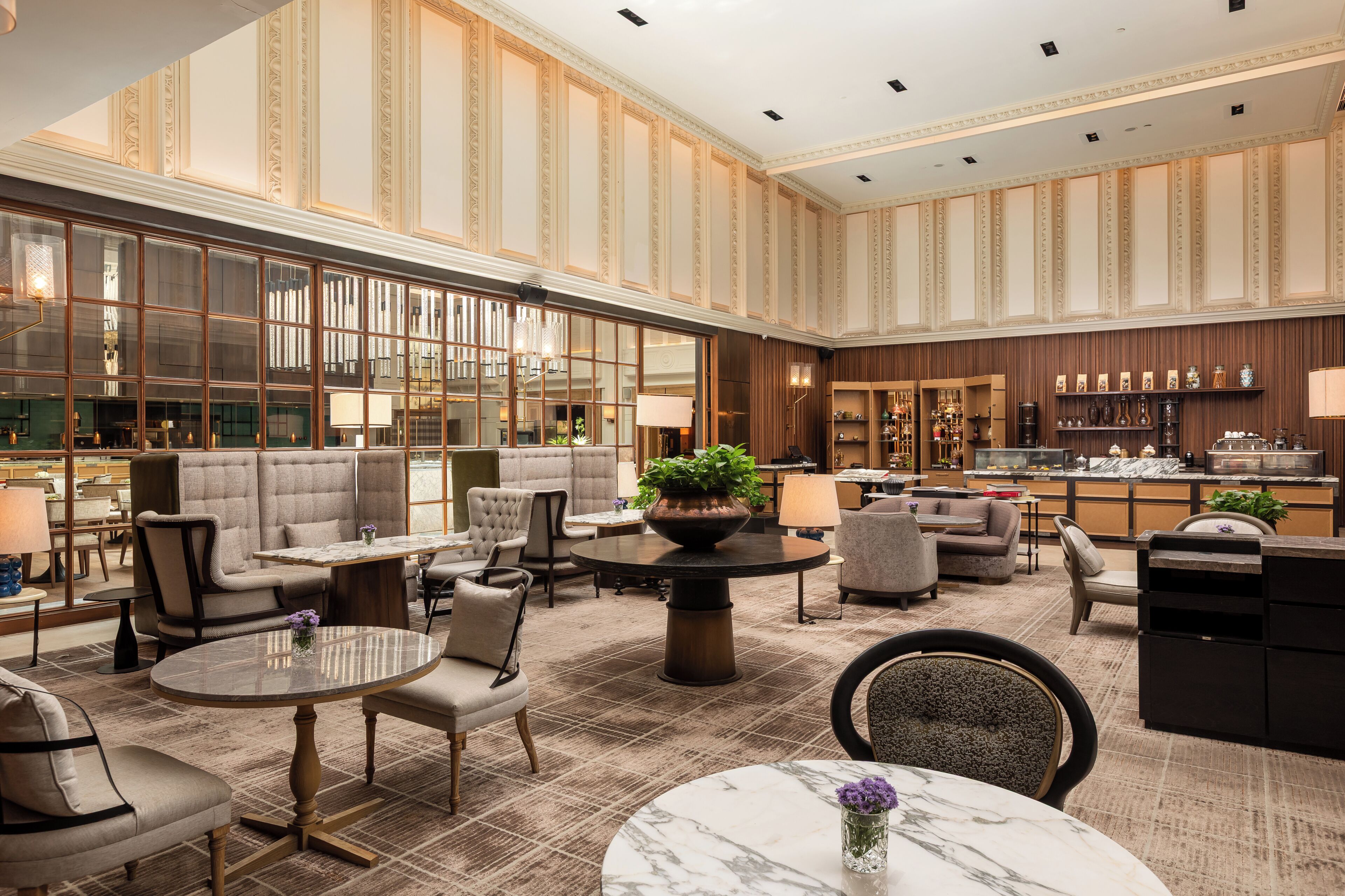 A spacious lobby with seating areas, a bar, and a reception desk.