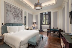 Un dormitorio espacioso con una cama grande, un escritorio y una silla.