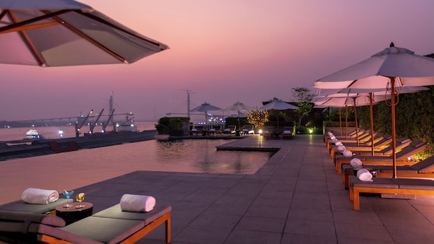 A rooftop pool area with lounge chairs and umbrellas, overlooking a body of water. - The ERAVATI Sule Grand Yangon (Yangon)