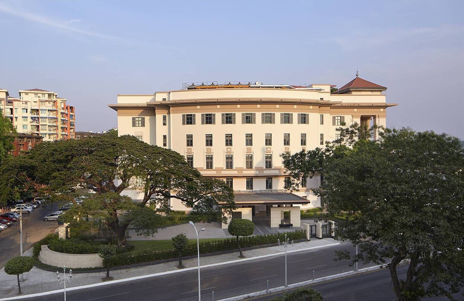 A large, multi-story building with a symmetrical facade, a central entrance, and a flat roof.