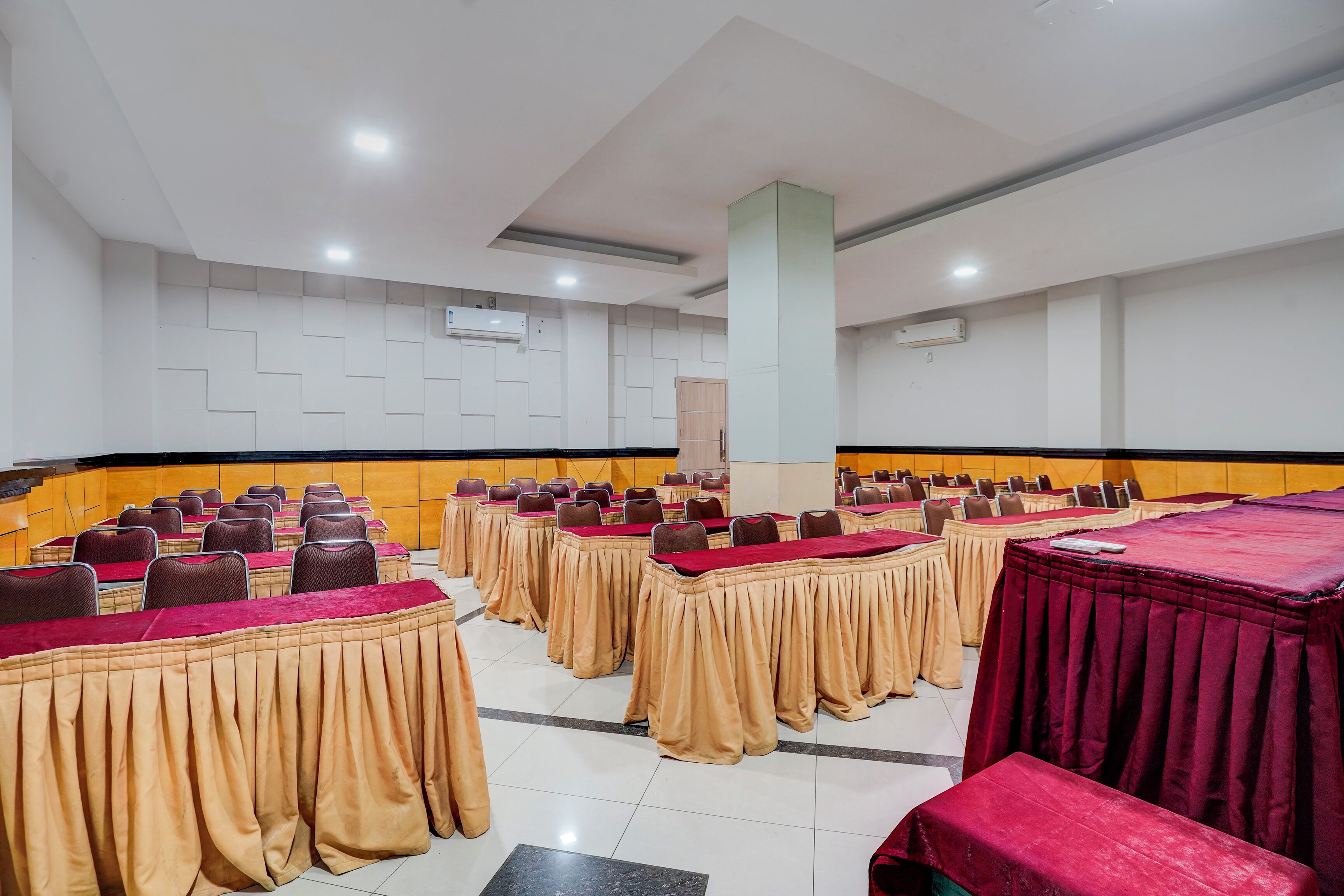 Un salón de conferencias con varias mesas y sillas dispuestas en filas.