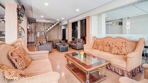 A spacious living area with a sofa, armchairs, and a coffee table. A staircase is visible in the background leading to an upper floor. - Townhouse Oak Padang near RTH Imam Bonjol (Padang)