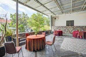 Enjoy meals in a shaded outdoor dining area with a round table and comfortable seating for four.