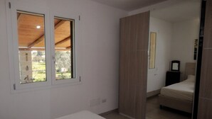 A bedroom with a large mirror, a bed, and a wardrobe. - Villa Maresca- countryside house in Carovigno (Puglia)