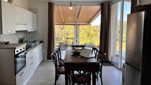 A modern kitchen with a dining area, large windows, and a view of the outdoors. - Villa Maresca- countryside house in Carovigno (Puglia)