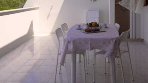 A balcony with a table set for two, chairs, a ceiling fan, and a view of the sky. - Casa Marisa, Salento by design. Within walking distance of the pearls of Salento! (Torre Saracena)