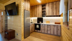 Une cuisine moderne avec des meubles en bois, un réfrigérateur en acier inoxydable et un four encastré.