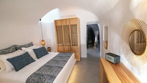 Une chambre à coucher avec un lit, une armoire en bois, un miroir et une petite table sur laquelle se trouve une radio.