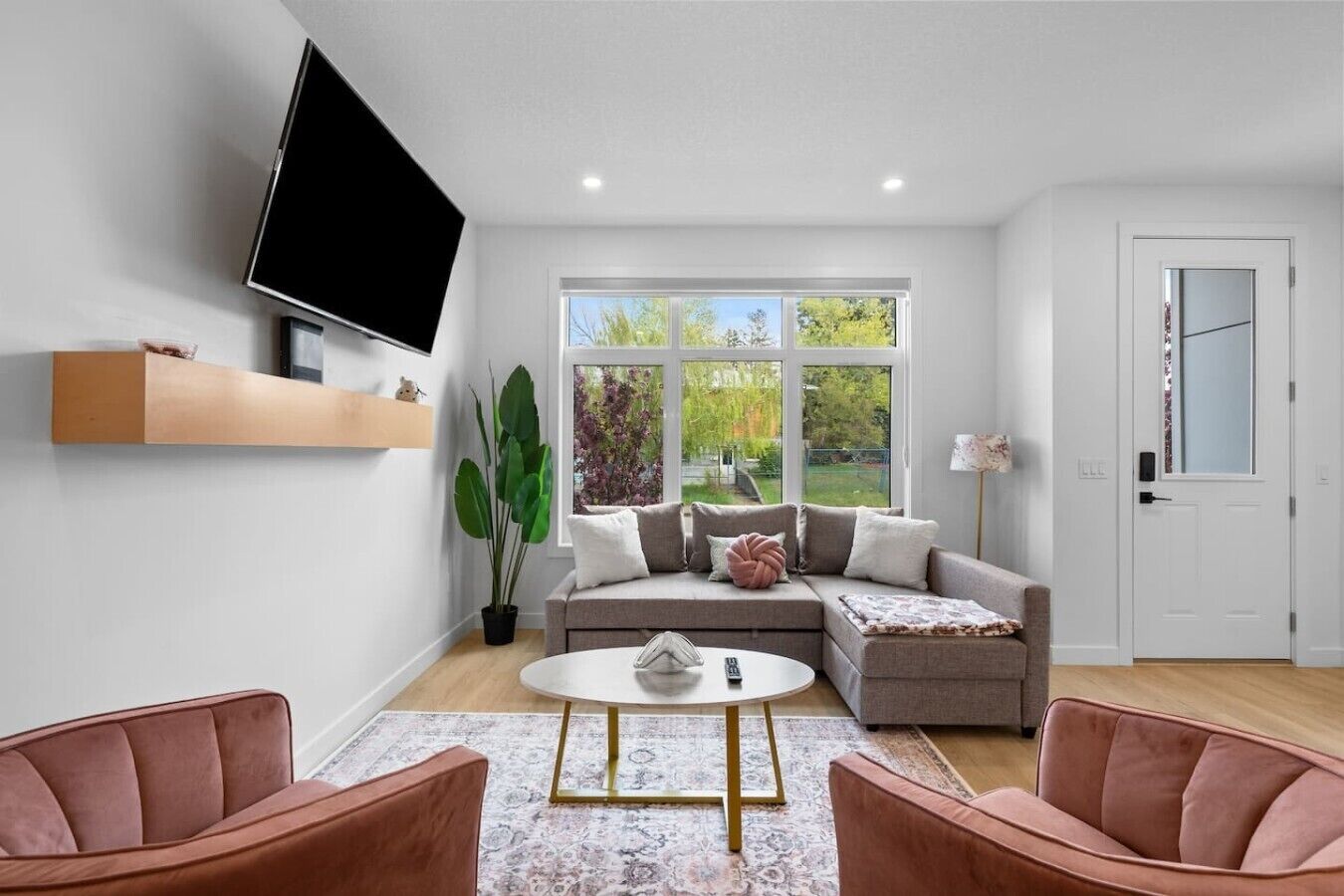 A modern living room with a sofa, coffee table, and two armchairs.