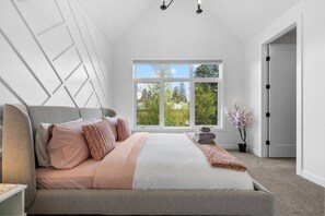 Un dormitorio con cama, ventana, planta en maceta y puerta.