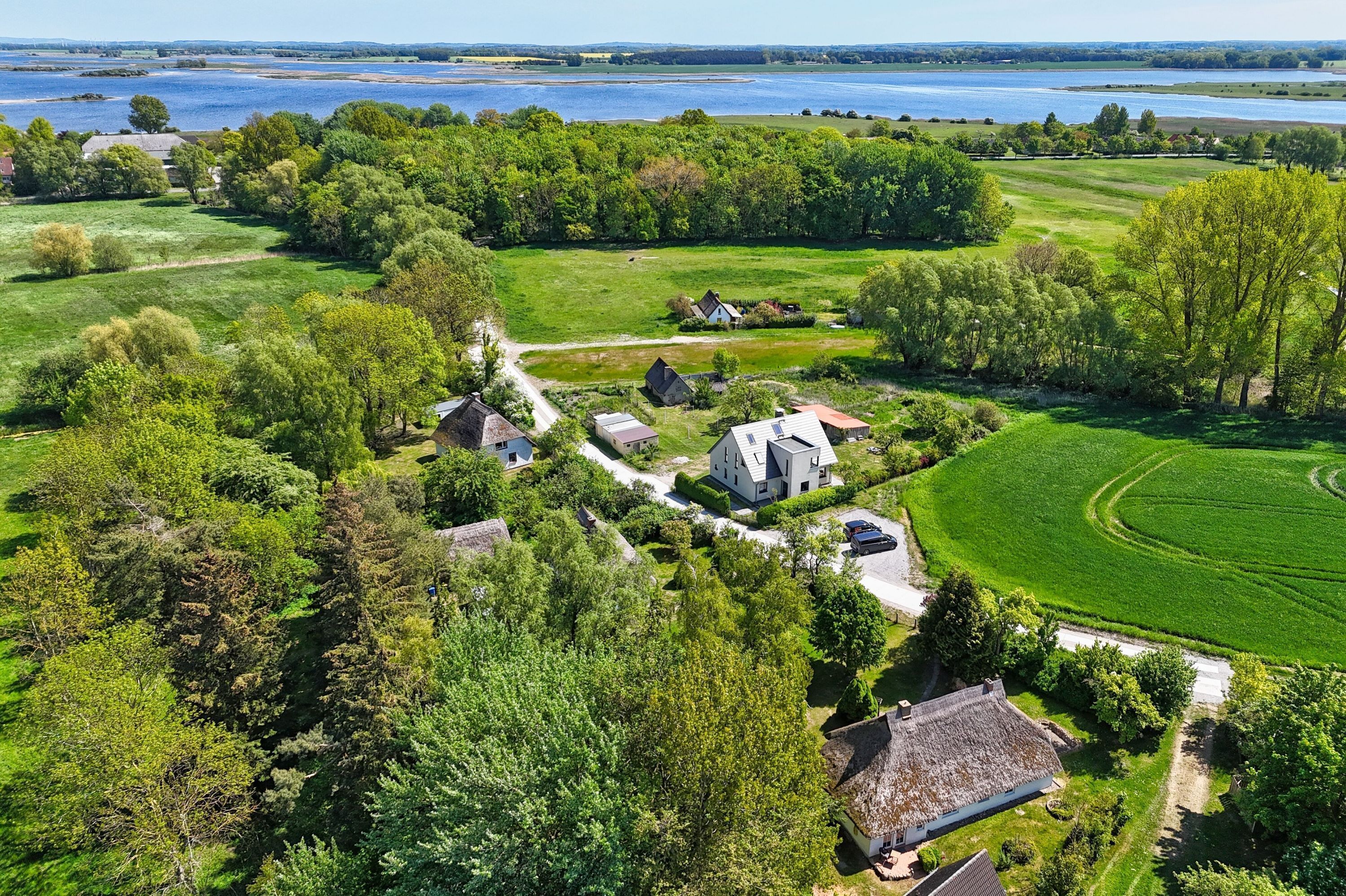 Ländliche Landschaft mit Golfplatz, Häusern und einem See.