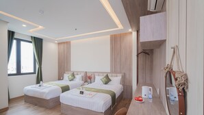 Ein Hotelzimmer mit zwei Betten, einem Holztisch, einem Spiegel und einem Fenster mit Vorhängen.