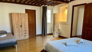 Une chambre à coucher avec un lit, une armoire et une fenêtre avec des rideaux.