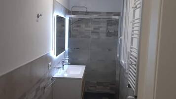 Chuveiro, secador de cabelo, bidê, toalhas de banho