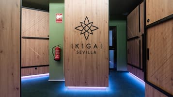 Un couloir aux murs lambrissés, sur lequel est apposée une enseigne indiquant « IKIGAI SEVILLE ».