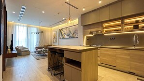 Une cuisine moderne dotée d’un îlot central, de tabourets de bar et d’un coin repas comprenant un canapé et une table basse.