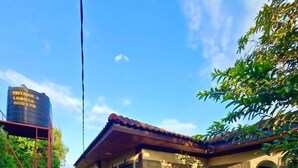 A small building with a stone facade, a tiled roof, and a paved entrance. - Charming 2-bedroom house in Arusha with WiFi (Arusha)