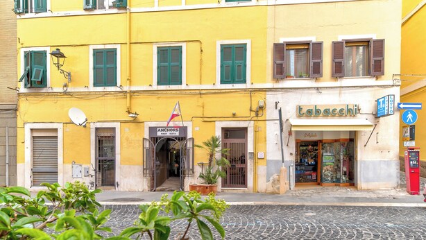 A yellow building with a storefront named 'Tabachi'. - La Posada by Rentbeat (Civitavecchia)