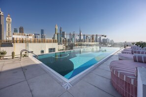 Piscine extérieure, parasols de plage, chaises longues