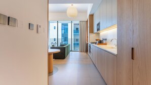 Eine moderne Küche mit Holzausstattung, einem runden Esstisch und Blick auf einen Balkon.