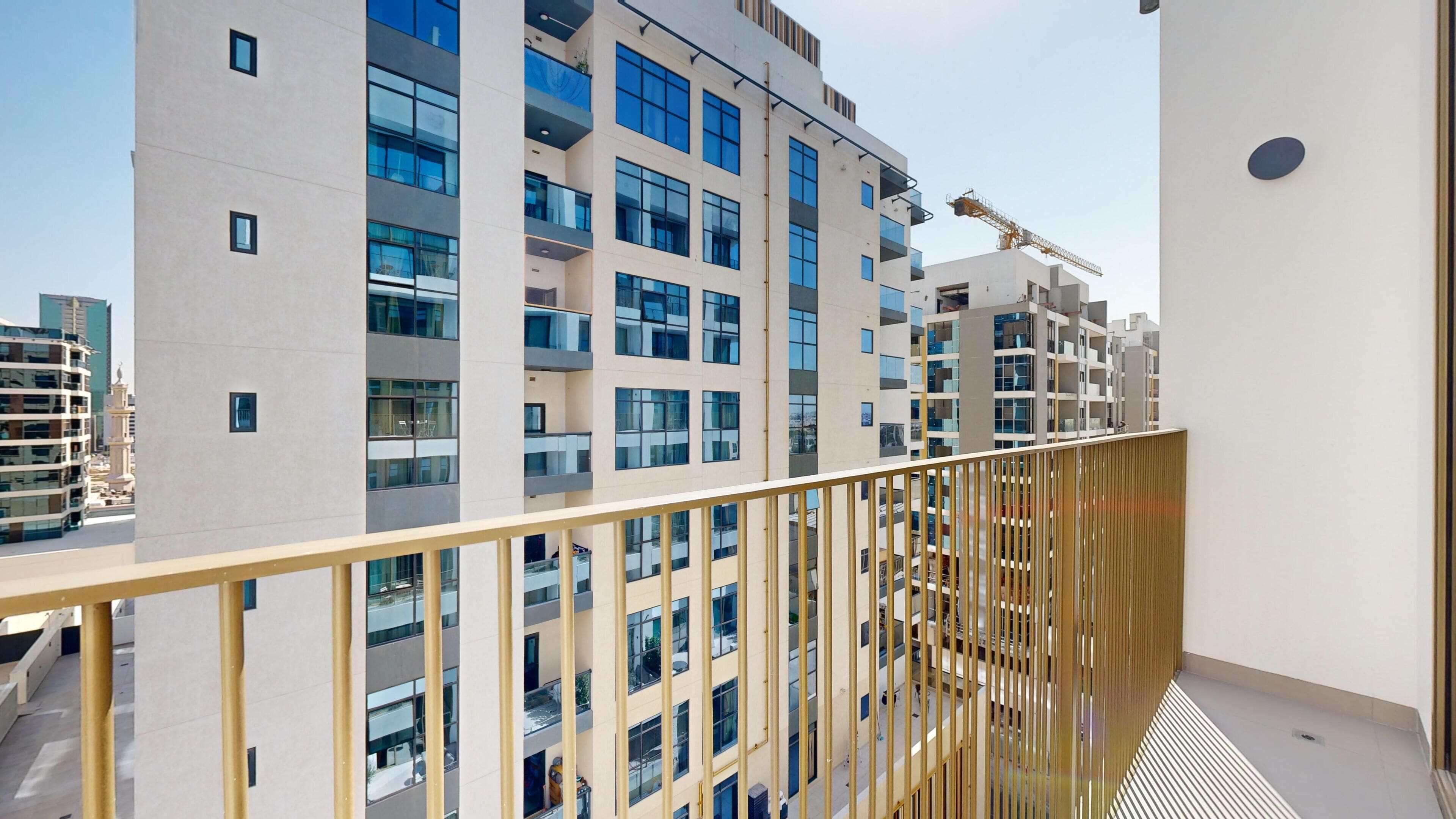 A modern high-rise building with multiple balconies and large windows.