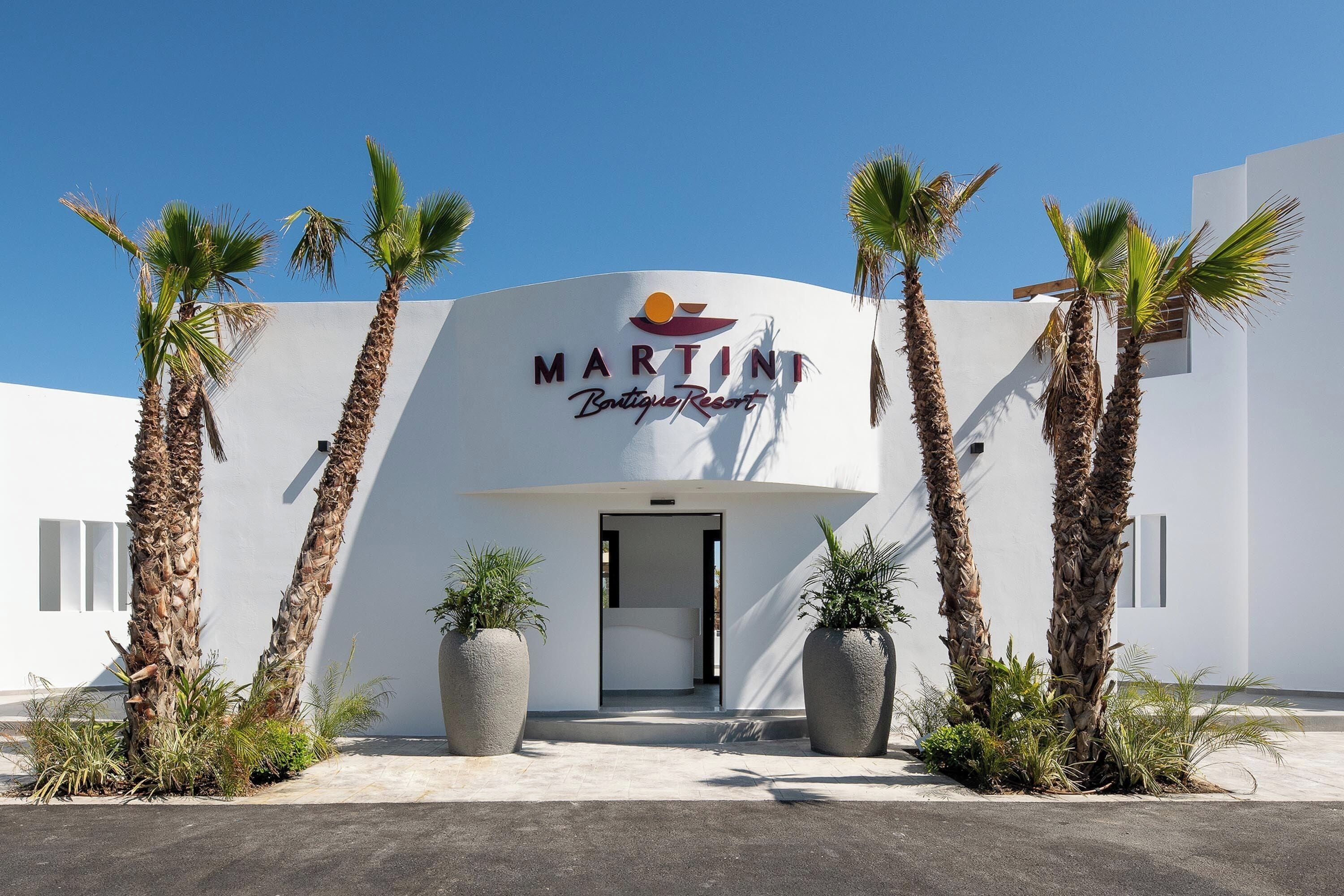 A modern building with a sign reading "Martini Boutique Resort".