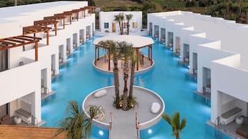 Un hotel moderno con una piscina central rodeada de edificios blancos, mobiliario exterior y palmeras.