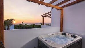 A hot tub with a view of the sunset and mountains.