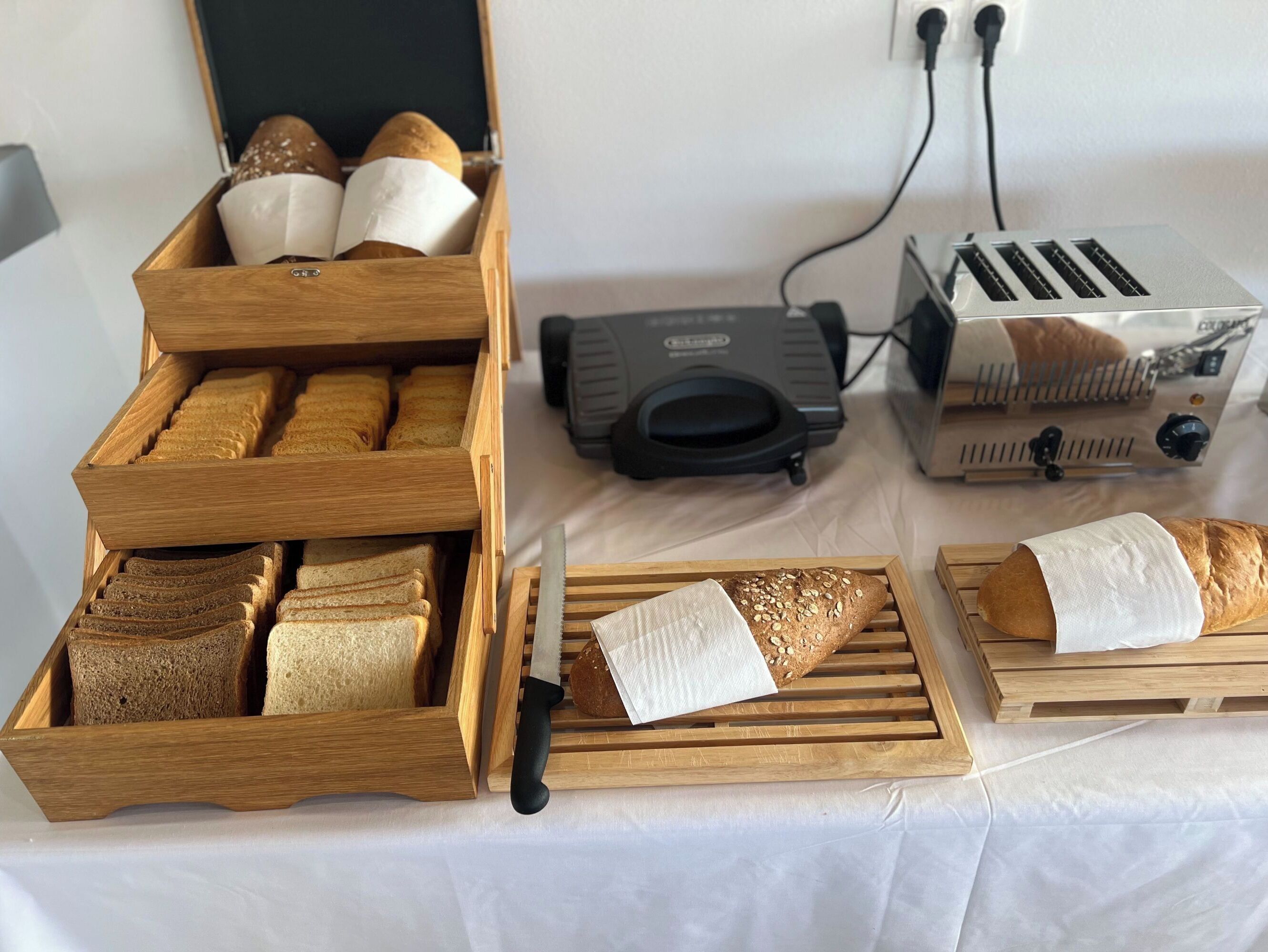 Uma cozinha com racks de pão de madeira, uma torradeira e um cofre para pão.