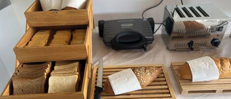 Uma cozinha com racks de pão de madeira, uma torradeira e um cofre para pão.