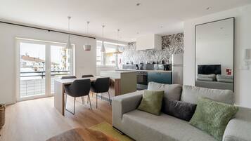 Relax in this spacious living area with a large sofa, dining table, and kitchen counter.
