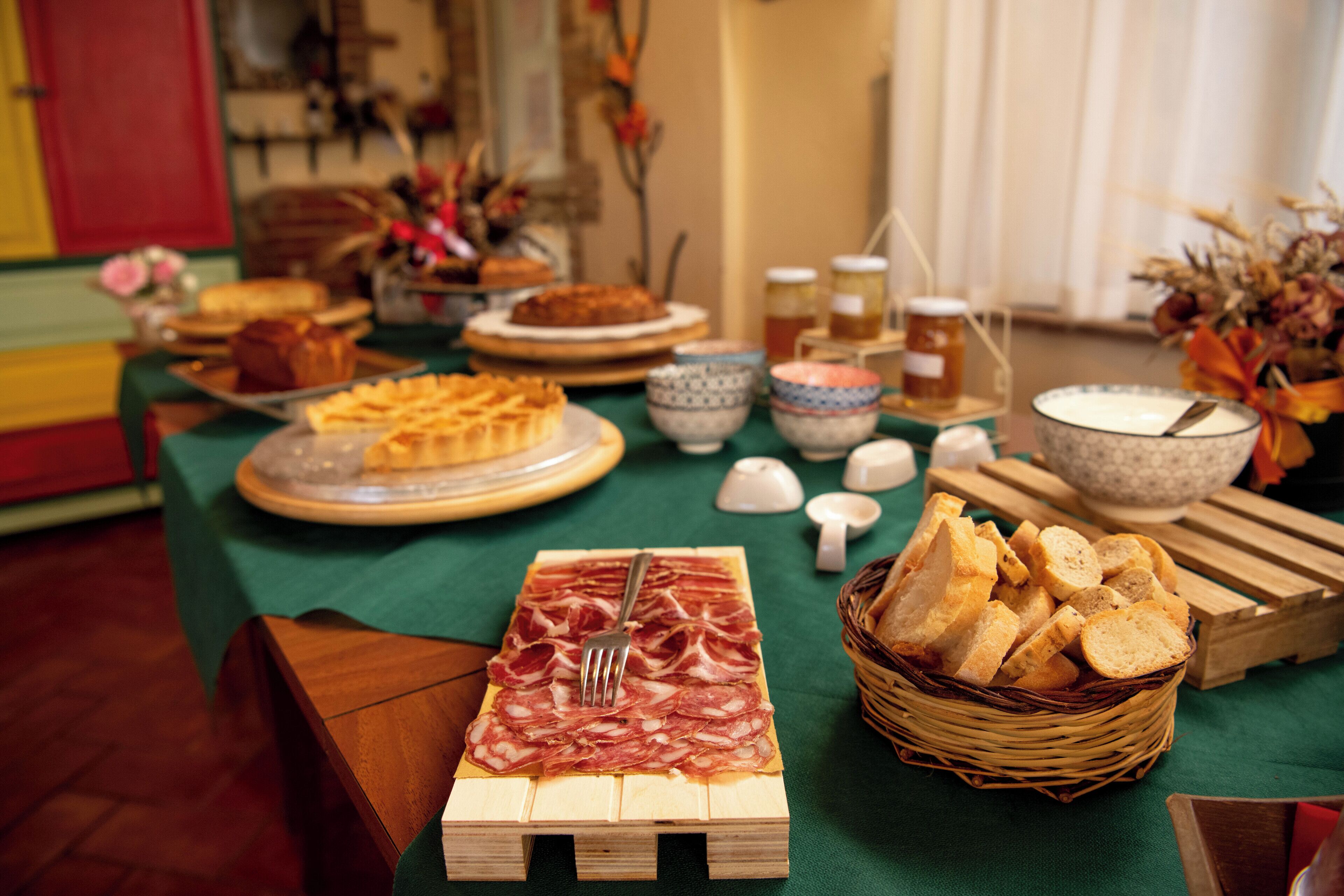 A table with various food items including bread, pastries, and a selection of meats.