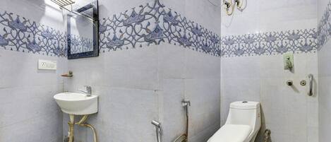 A bathroom with a sink, toilet, shower, and towel rack.