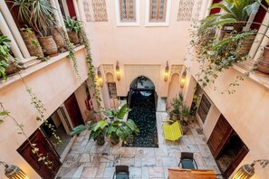 A courtyard with a fountain, potted plants, and seating areas. - Riad Mayan & Spa (Marrakech)