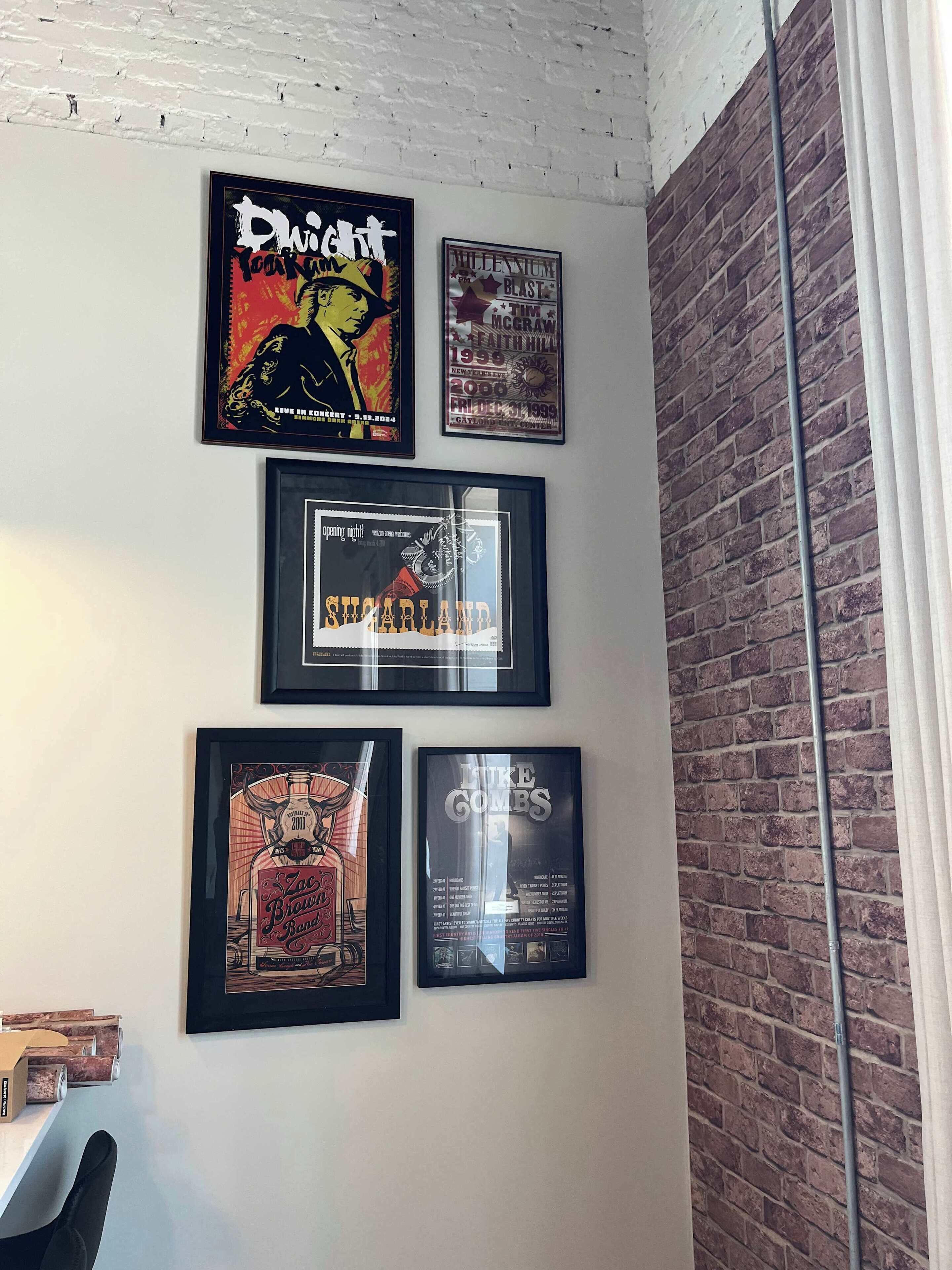 A wall with framed posters of various bands and events.