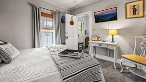 Ein ordentlich eingerichtetes Schlafzimmer mit Bett, Nachttisch, Stuhl und einem Bild an der Wand.