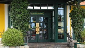 Una entrada de edificio con puerta verde, escalones y un letrero sobre la puerta.