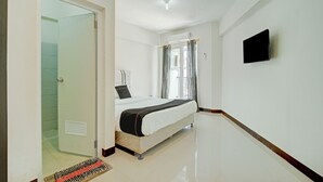 A hotel room with a bed, a television, and a door leading to a bathroom. - Collection O near Terminal Pulo Gebang formerly Sentra Timur - Tower Sapphire (Jakarta)
